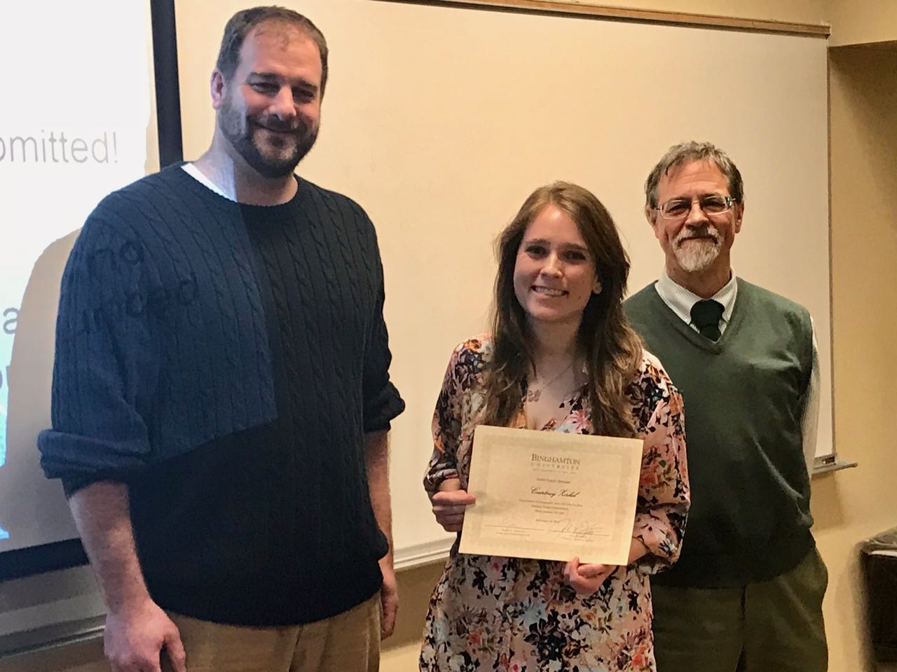 Kevin Heard and Lucius Willis presents Courtney Zirkel with an award at the third annual GIS Day, hosted by the geography department, on Friday.