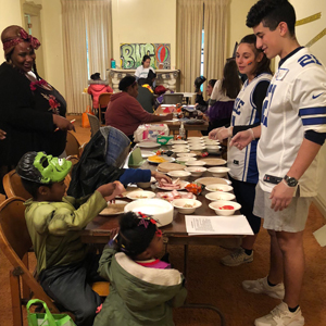 Emerging Leaders Program students serve snacks at a Halloween-themed Community Cafe for the North of Main Street community in Binghamton.