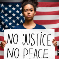 An image of a female person of color in front of an American Flag holding a sign that says 