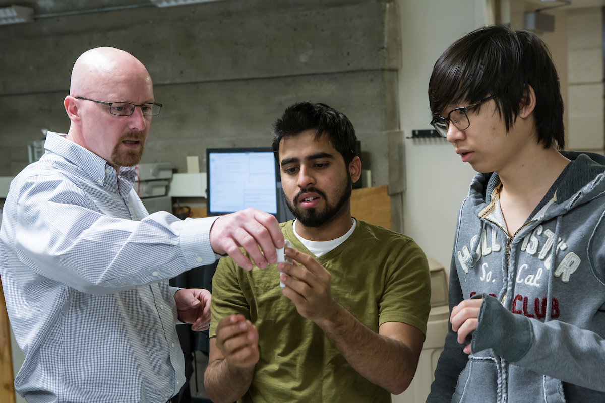 At left, Professor Doug Summerville, MS ’94, PhD ’97, works with students on a robotics project in 2014.