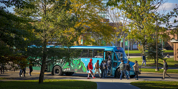 Students catch the Off Campus College Transport (OCCT) bus at a stop near the University Union.