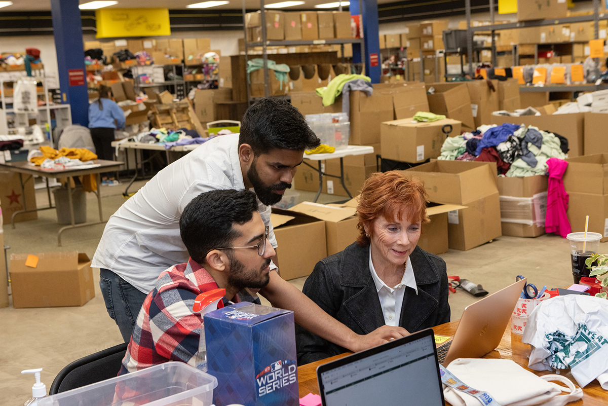 From left, Mohammed-Khalil Ghali, MS '24, and Srimadhaven Thirumurthy '23 help Kim Myers from Locker Room 345 with the program they created to track orders.