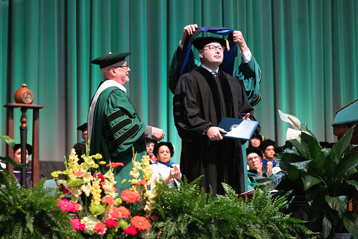 Retired United States Army Lieutenant Colonel Alexander Vidman '98 receives the State University of New York (SUNY) honorary Doctor of Laws degree from Donald Hall, provost and executive vice president of academic affairs (left) and Binghamton University President Harvey Stenger.