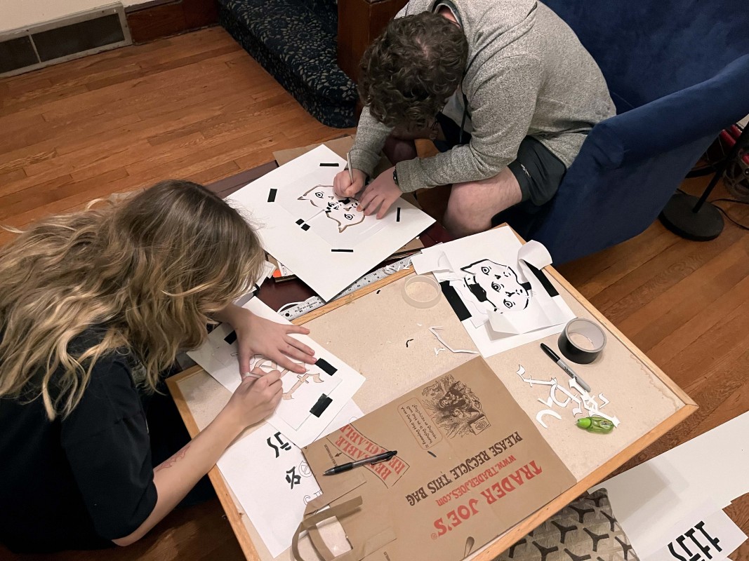 Students stencil logos for the annual Student Experimental Film Festival, which is organized by CINE 300: Curating Film and Video.