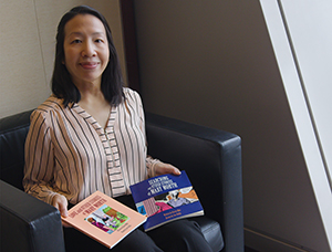 Karen Moy sits with two books that feature collections of 