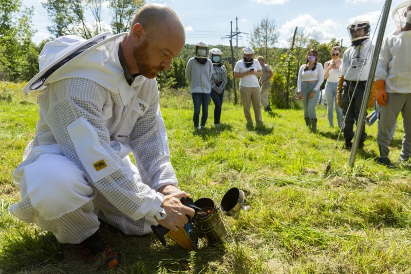 George A. Meindl, (pictured here) instructor of the Environmental Studies Program, Tina Chronopoulos, associate professor of Middle Eastern and Ancient Mediterranean Studies and Sean Cummings, PhD '11, adjunct lecturer in the Environmental Studies Program, host a beekeeping demonstration at Binghamton University Acres to students of the Binghamton University Bees Club, Saturday, September 11, 2021.