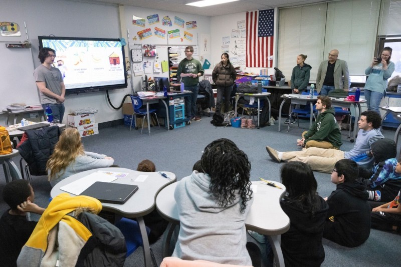 Nirav Patel, lecturer in the Environmental Studies Program at Harpur College of Arts and Sciences, and his students teach pupils at Theodore Roosevelt Elementary in the City of Binghamton about the impact of pollution on the environment, Thursday, March 28, 2024. Here, students Truman DiBartolo, William Cohen and Amy Guo give a presentation.