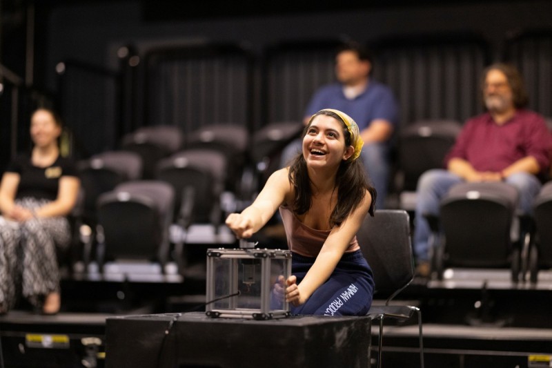 Samantha Goldman, a senior majoring in theatre and English, generates electricity during a performance of Pedal-Powered Theater, the brainchild of Nathan Wheatley, a lecturer and lighting designer in the Theatre Department.