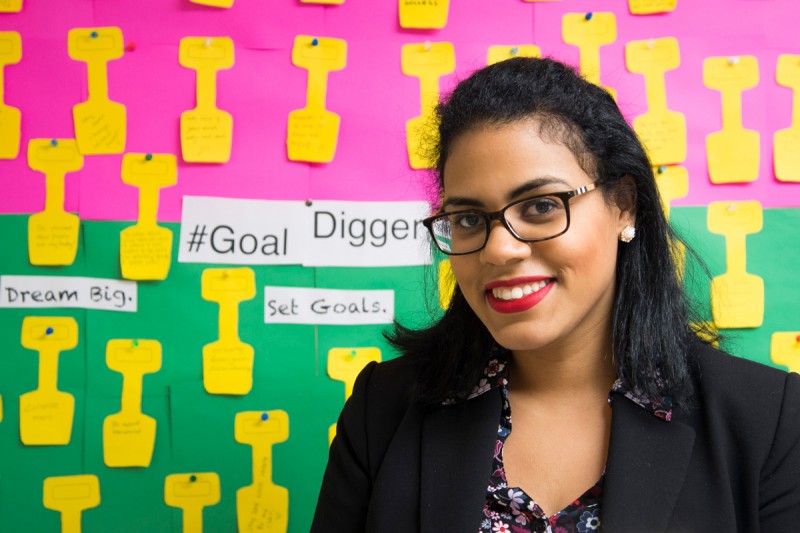 Andreina Rosa '10 stands in front of her student #goaldigger goal/motivation wall in her office.