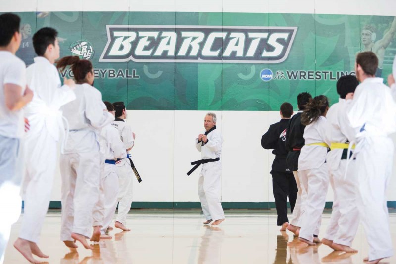 Adjunct Lecturer John Fletcher leads students through warmup exercises at the beginning of an Intermediate Taekwondo course.