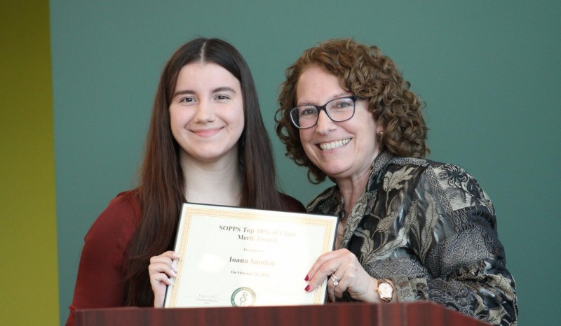 Third-year pharmacy student Ioana Sandru accepting her Top 10% of Class Merit Award from Associate Dean for Academic and Student Affairs Jude DeLuca.