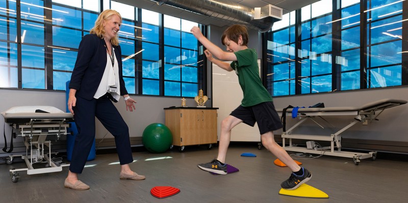 Anne Schneider, clinical assistant professor and assistant director of clinical education, Division of Physical Therapy, works with Matthew Mooney in the Physical Therapy Lab at Binghamton University's Health Sciences Building.