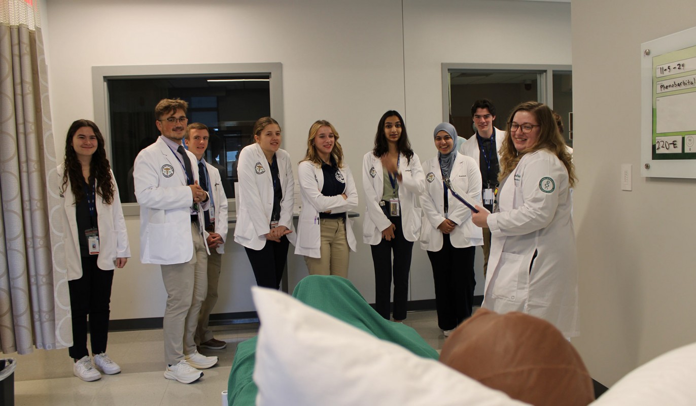 Clinical Assistant Professor of Pharmacy Practice Alexandra Rola (far right) with students from BOCES' New Visions program looking at high-fidelity manikins in the school's Skills Lab.