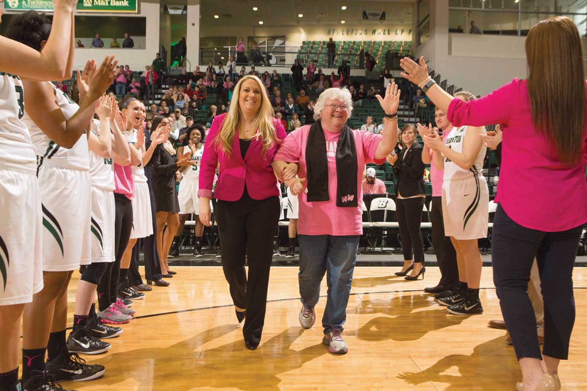 Linda Cimino escorts her mother, Mary Ellen Cimino, a survivor of a brain aneurysm and two breast cancers, at last season’s Play 4Kay game. Play 4Kay is an annual opportunity for the nation’s coaches and student-athletes to raise awareness and funds for women’s cancer research. The only game Linda has missed in her coaching career was for one of her mom’s surgeries. Mary Ellen watches her daughter in action online and stays with her for a few weeks every season to attend games in person.