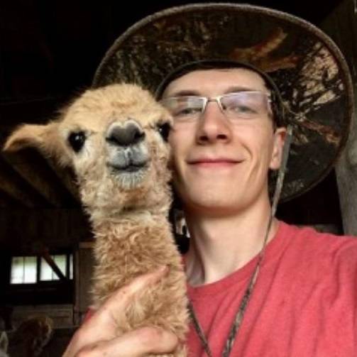 Dyllan May poses with a baby alpaca